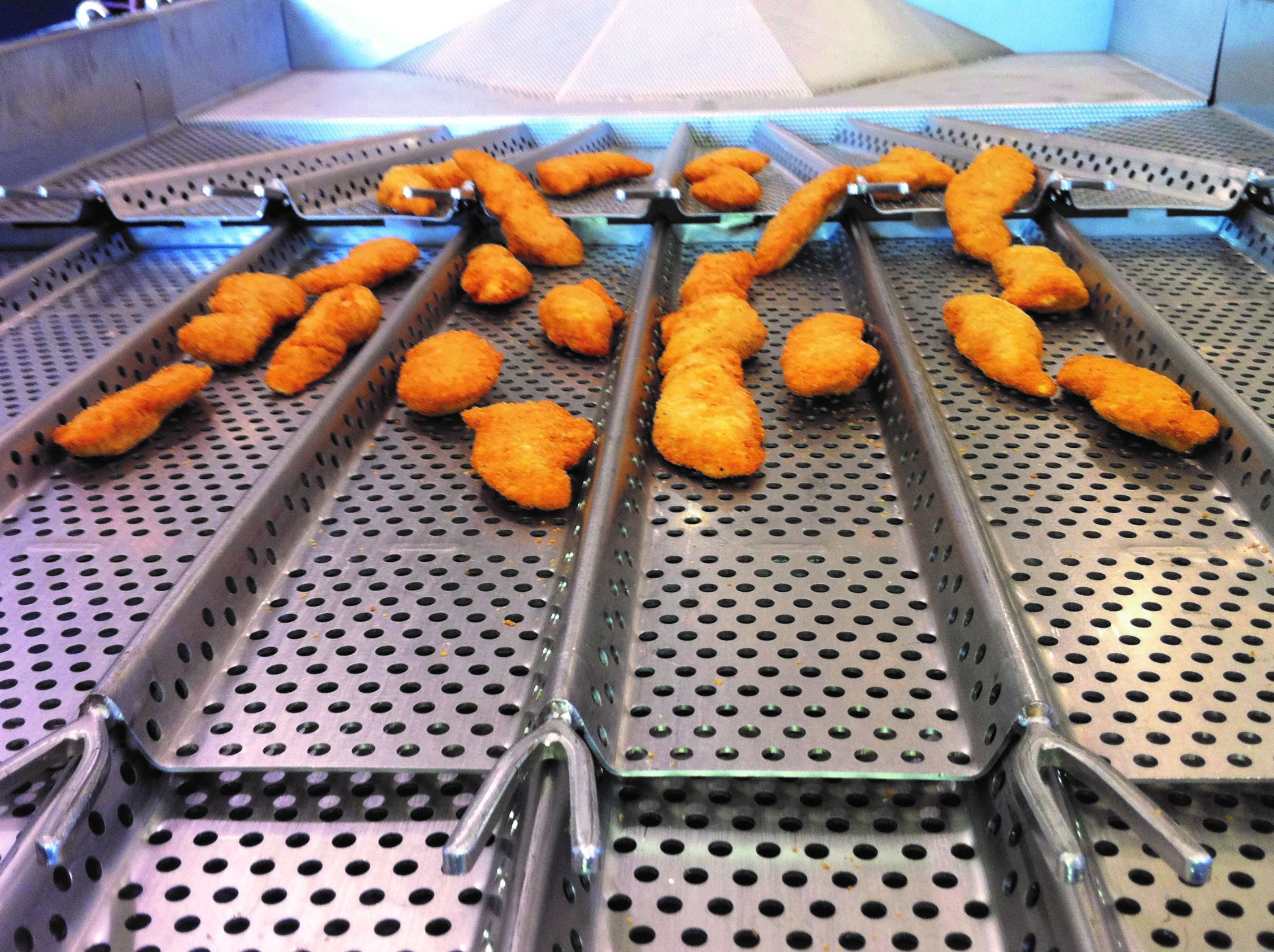 Chicken tenders being laned on a PFI vibratory conveyor
