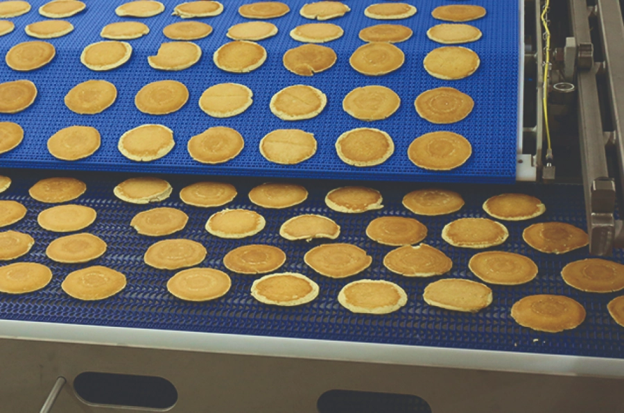 Pancakes accurately deposited on a conveyor by a PFI Retractor