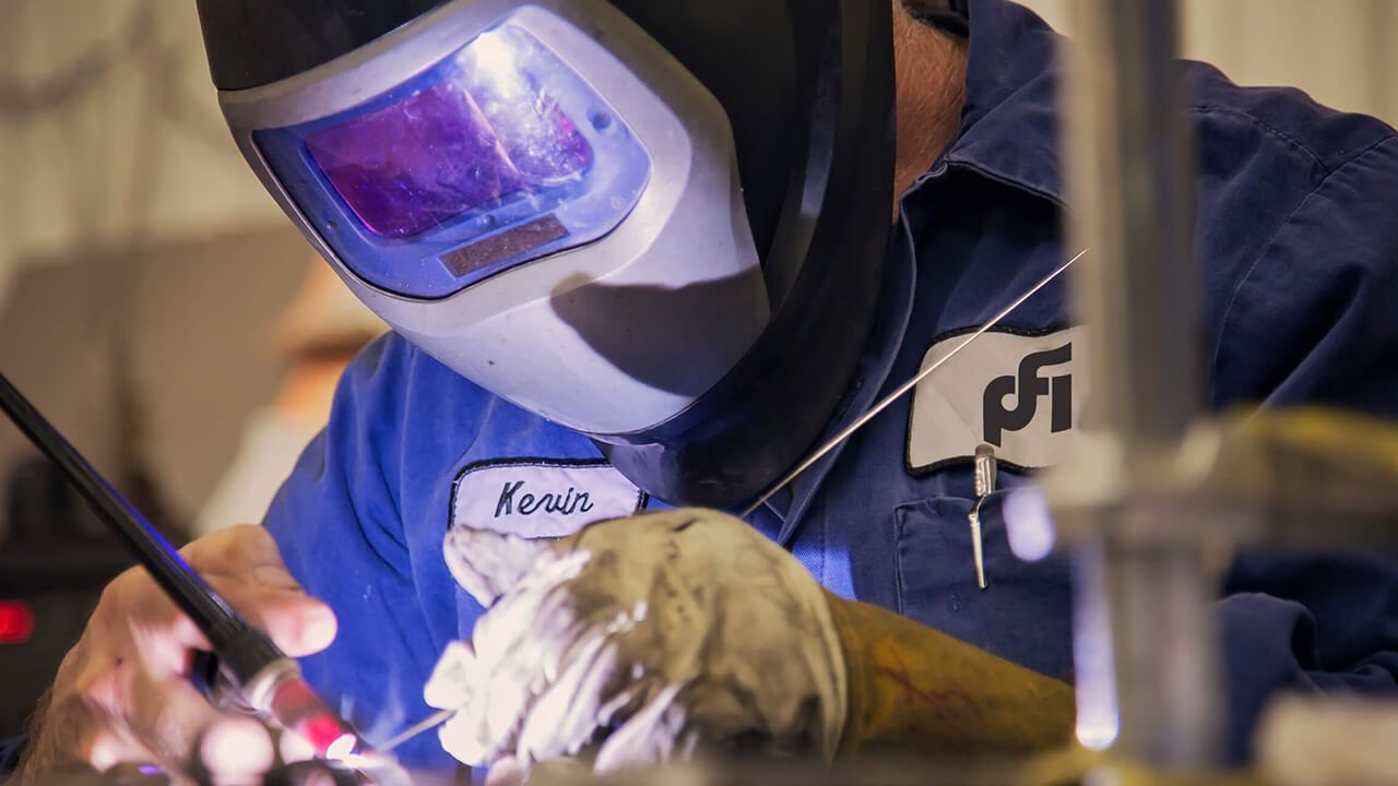 PFI technician welding.