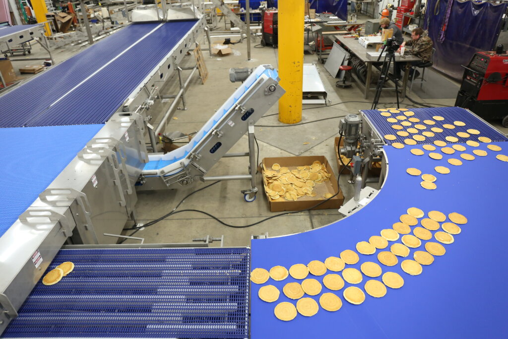 close up image of sanitary conveyors in a plant producing pancakes.